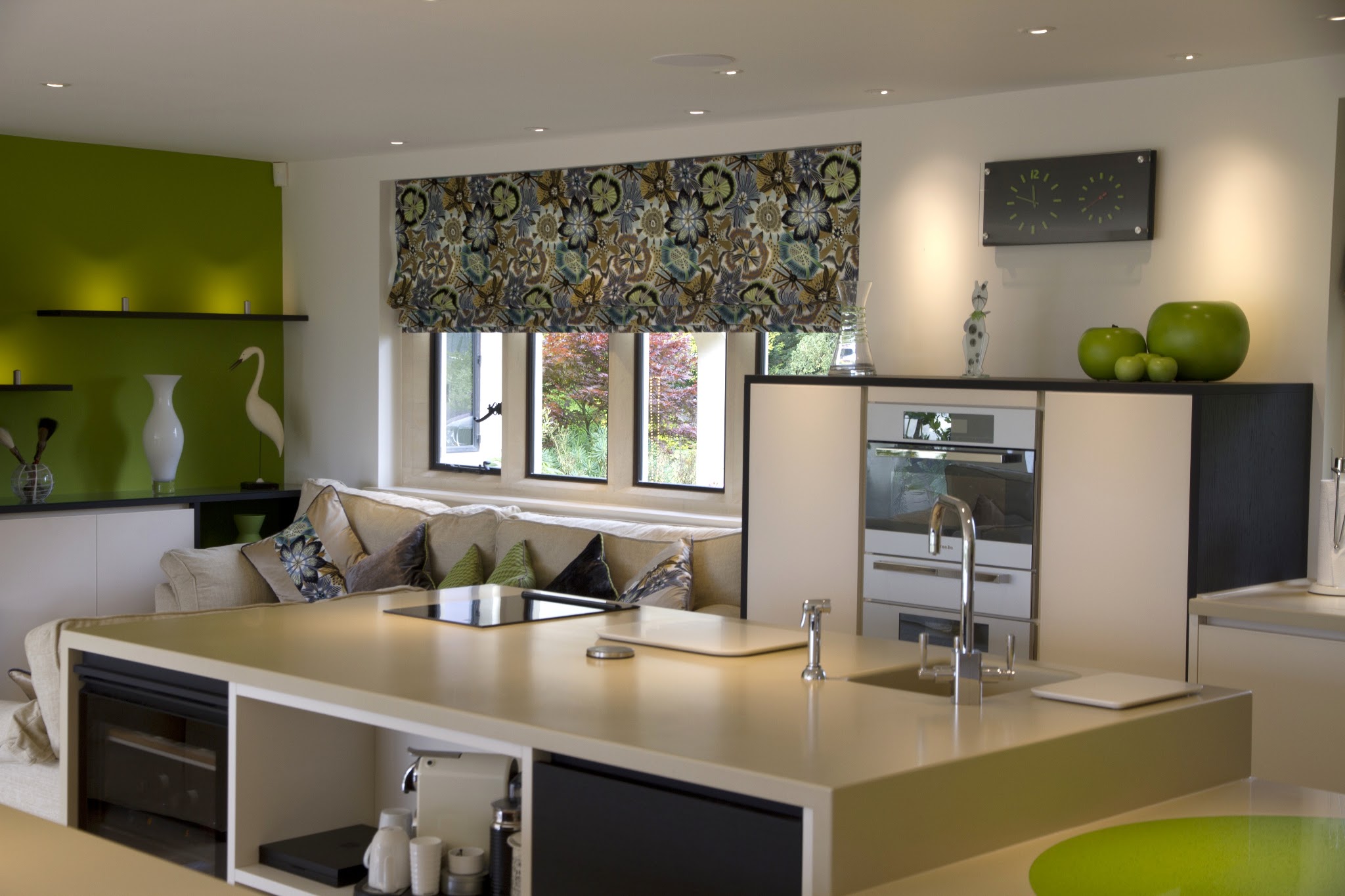 An open-plan kitchen and living space with a lime green feature wall